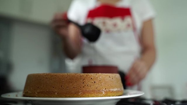 woman preparing carrot cake. Chocolate glaze pouring on homemade cake. Brazilian carrot cake. Topping chocolate on carrot cake. June Partys sweet
