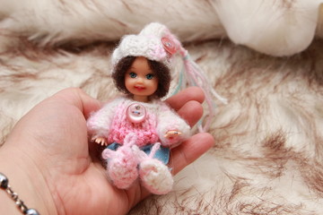 Fototapeta premium A small beautiful child's doll, posing in beautiful places. 