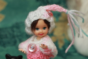 A small beautiful child's doll, posing in beautiful places. 