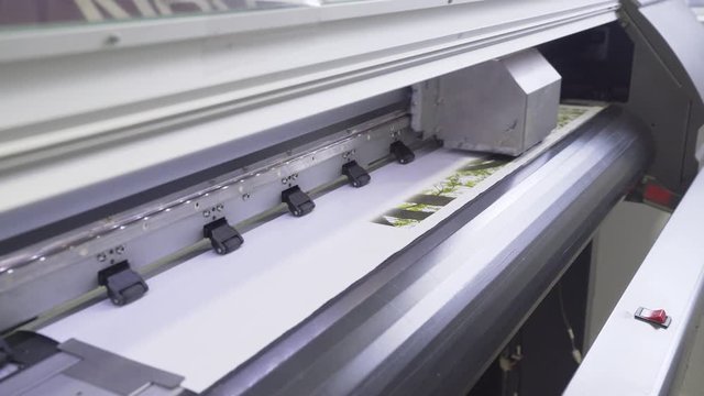 Industrial printing modern digital inkjet printer puts a picture on a cloth canvas
