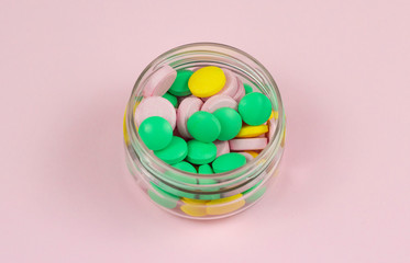 pills in a bottle isolated on pink background