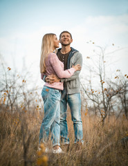 Man And Woman Stands Embracing On Grass Outdoors