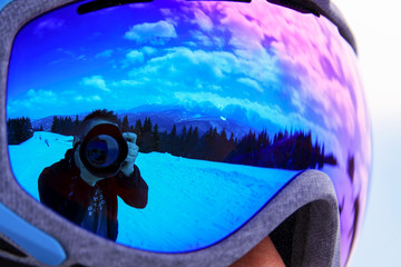 Photographer and camera reflected in goggles