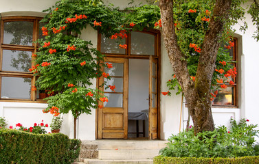 Fototapeta na wymiar Door entry into house from garden with flowers