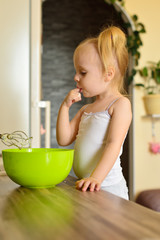 Girl makes a cake and licks a finger