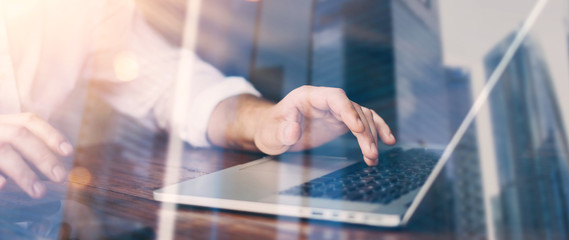 Close-up photo of male hands with laptop. Man is working remotely at home. Distance job