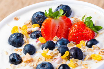 Yogurt with granola, strawberries and blueberries.