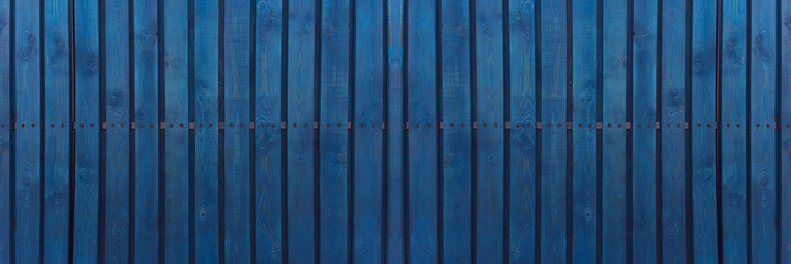 Blue wooden wall paneling texture, banner. Background of old wood slats, vintage style. Hardwood dark blue timbered structure.