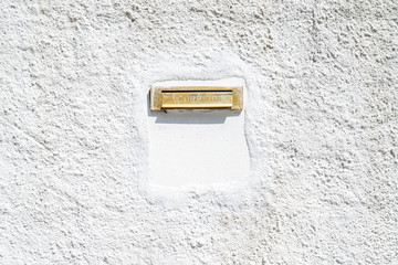 Mail stuck in the old wall painted white.