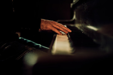 Hands playing piano keys in dark space © Z2