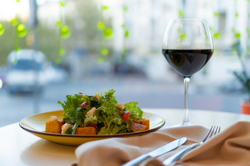 salad with baked vegetables, herbs, nuts and kerm cheese and glass of wine.