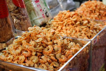 Small peeled prawns in containers at a street stall