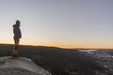 Fototapeta premium Young man looking at the views form the top of a mountain.