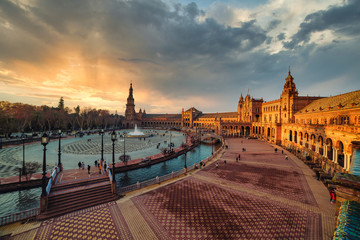 Dramatic scene of Plaza España in Seville at sunset - obrazy, fototapety, plakaty