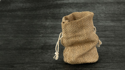 Burlap sack on dark background. Jute Empty Sack mock up. Copy space for text. Traditional Vintage Sack mock up. Linen sack copy space for product.