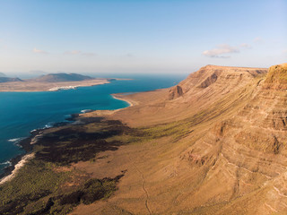 Fototapeta na wymiar Aerial shot of cliffs in north of Lanzarote with view of La Graciosa, Canary Islands