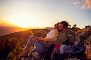 Couple Man and Woman sitting on cliff enjoying mountains and clouds landscape Love and Travel happy emotions Lifestyle concept.