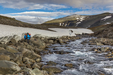 female hiker witt backpack going to cross the mountain river