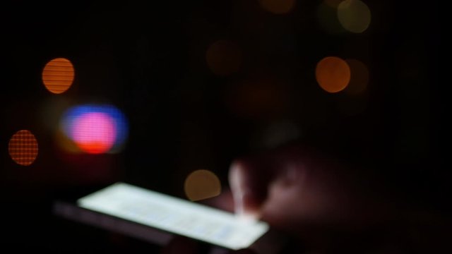 Smartphone using at night - blurred out of focus concept footage