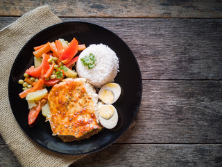 Food dish with Meat hideout with cassava with melted cheese and vegetables. Rustic wood background.