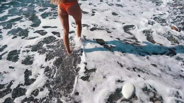 legs of a girl walking on the shore