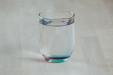 a glass of water on wooden background.