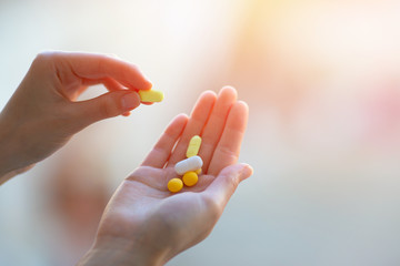 A Handful Of Colored Pills On A Female Hand