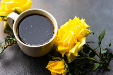 Cup of coffee and yellow roses