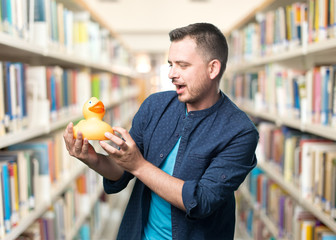 Young man wearing a blue outfit. Holding a toy duck.