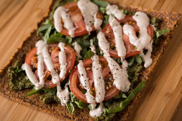 Raw Pizza with gluten free crust, tomatoes, cashew cheese with juice in the background