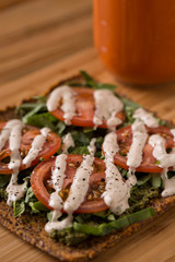 Raw Pizza with gluten free crust, tomatoes, cashew cheese close up shallow depth of field