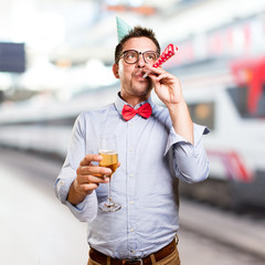 Man wearing a red bow tie and party hat. Holding a champagne glass.