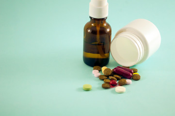 White bottle with mix pills on green background