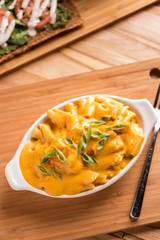 Macaroni and cheese gluten free and vegan with fresh raw pizza in the background