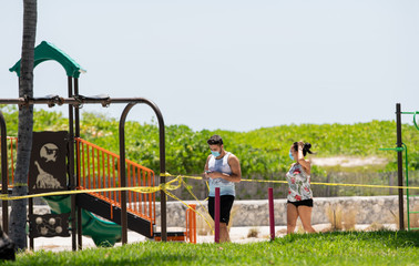 Tourists in Miami Beach walking with face masks social distancing Coronavirus Covid 19