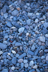 Fototapeta na wymiar The small stones on the beach in blue colors