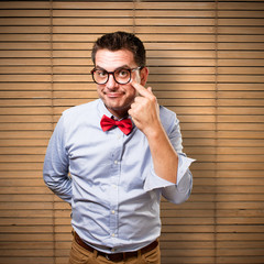 Man wearing a red bow tie. Pointing to his eye.