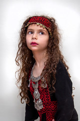 Arabian adorable girl in bedouin traditional cloths and ramadan kareem lamp arabic typography