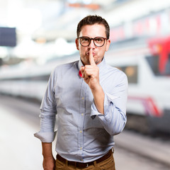 Man wearing a red bow tie. Doing silence gesture.