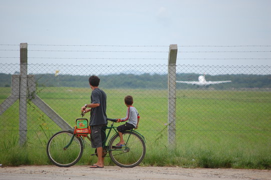 Father And His Son Watching The Take Off Flight.