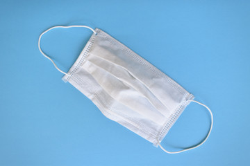 Mascarilla descartable sobre fondo celeste
