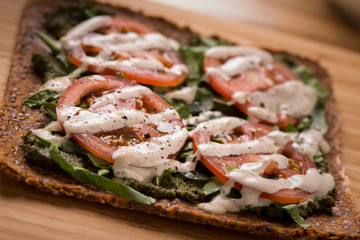 Raw Pizza with gluten free crust, tomatoes, cashew cheese close up show dof