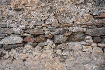 Stone Wall Texture Background with asymmetrical stones stacked together to form a vintage wall