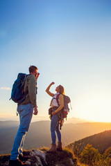 Couple on Top of a Mountain Shaking Raised Hands