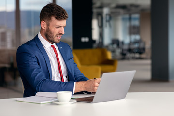 Fototapeta premium Portrait of worried young man at workplace. Stress concept