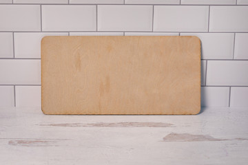 Empty blank void of writing wooden sign leaning on white subway tile background add writing
