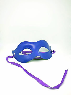 plastic carnival purple and blue mask with ribbons to hide the area around the eyes, on a white background