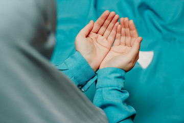 Muslim woman in a headscarf praying and a rosary in the background
