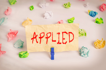 Text sign showing Applied. Business photo showcasing put to practical use as opposed to being theoretical Be applicable Colored crumpled papers empty reminder white floor background clothespin