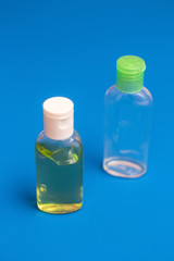 Antiseptic for hands, one full bottle and one empty. On a blue background